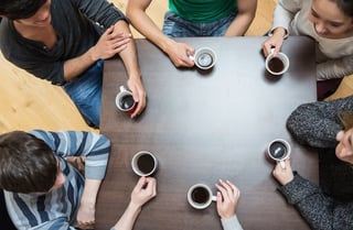 Students sitting around table drinking coffee in college cafe.jpeg